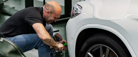 Professional installer applying PPF to a vehicle panel