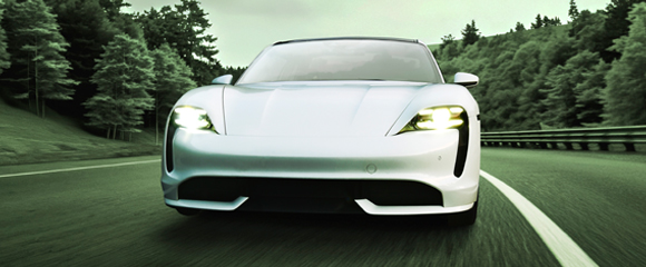 White performance car driving on a tree-lined road, representing vehicle owner protection solutions